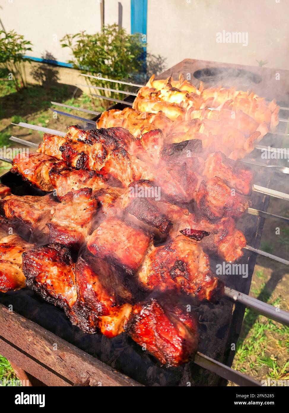 Marinierter Schaschlik, der auf einem Barbecue-Grill über Holzkohle zubereitet wird. Schaschlik oder Schischkebab in Europa beliebt. Stockfoto