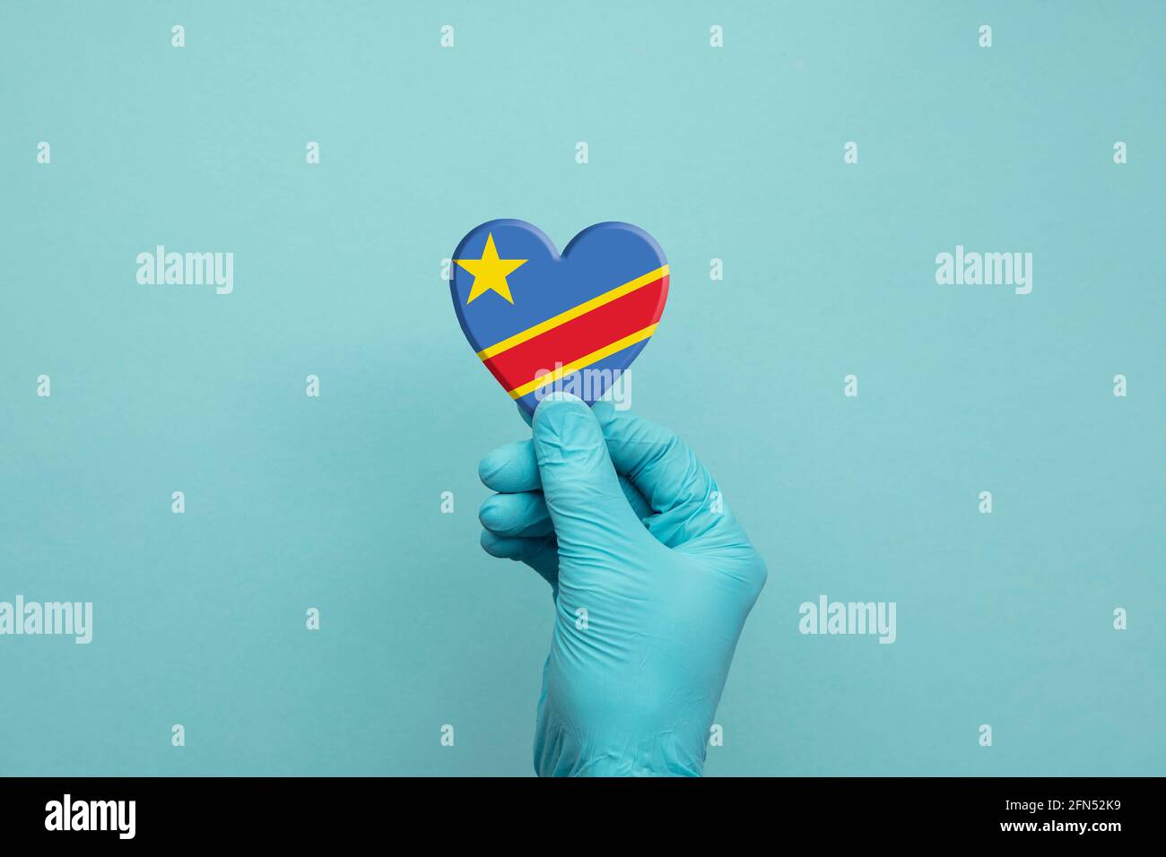 Hände mit schützenden chirurgischen Handschuhen, die das Herz der Kongo-Flagge halten Stockfoto