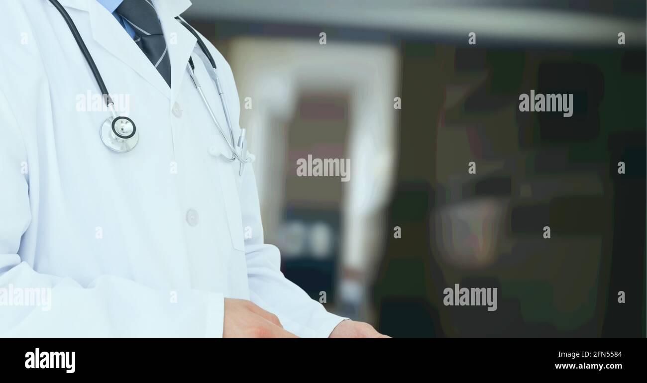 Zusammensetzung des mittleren Abschnitts des männlichen Arztes im Laborkittel mit Stethoskop über Krankenhaus außer Fokus Stockfoto