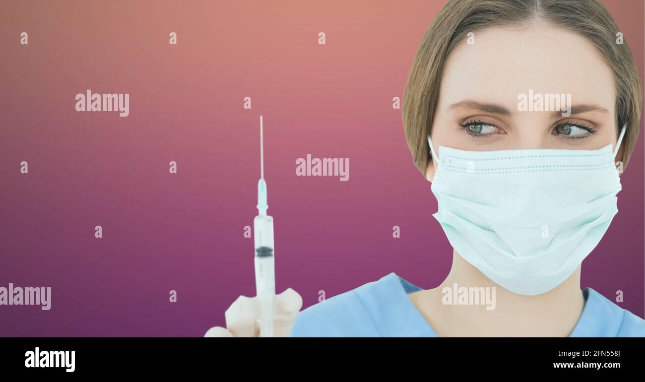 Kaukasische Gesundheitsarbeiterin trägt eine Gesichtsmaske mit einer Spritze Vor Verlaufshintergrund Stockfoto
