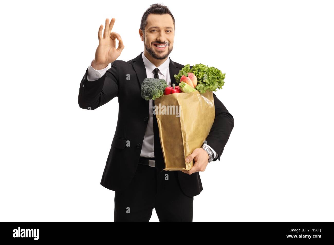 Zufriedener Geschäftsmann Kunde mit einem Lebensmittelbeutel gestikuliert ein gut schild isoliert auf weißem Hintergrund Stockfoto