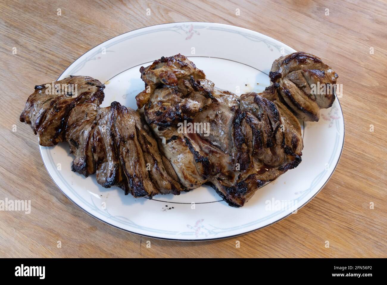 Butterflid Lammkeule, gekocht auf einem Grill und serviert auf einem Bone china Serviergericht, Suffolk UK Stockfoto