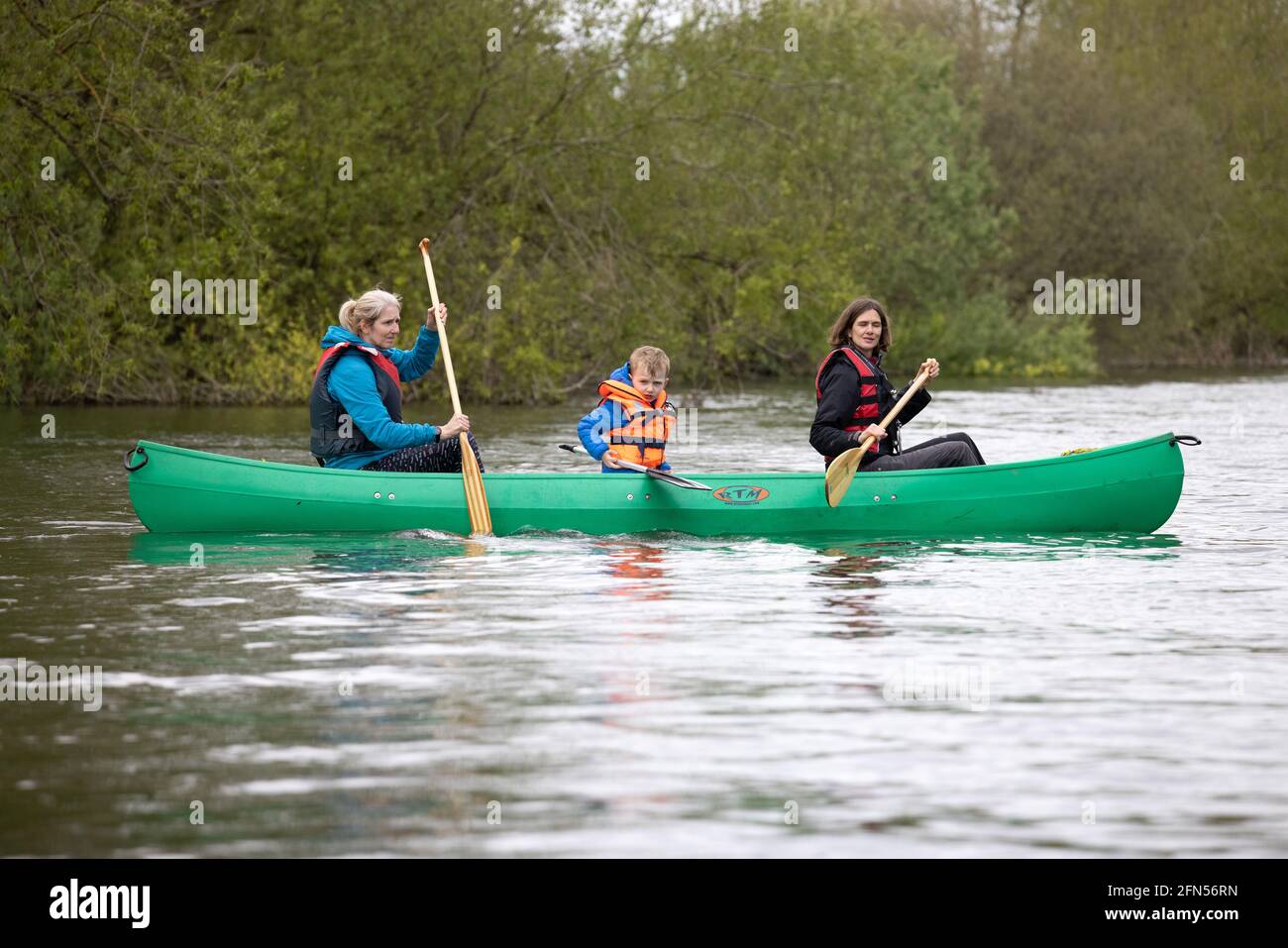 Outdoor Lifestyle UK: Familien-Kanufahren auf der Themse in Oxfordshire. Zwei Erwachsene und ein Kind in einem Kanu; die Themse, Oxfordshire England Stockfoto