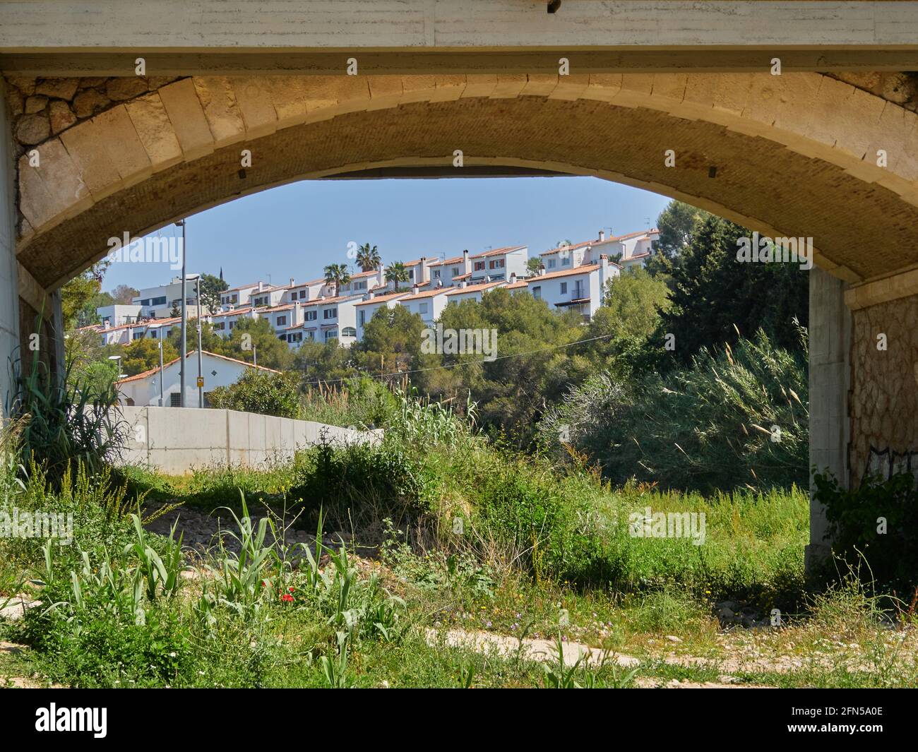 Blick auf verschiedene Häuser und die Wiese von über die Brücke in Sitges, Spanien an einem sonnigen Frühlingstag Stockfoto