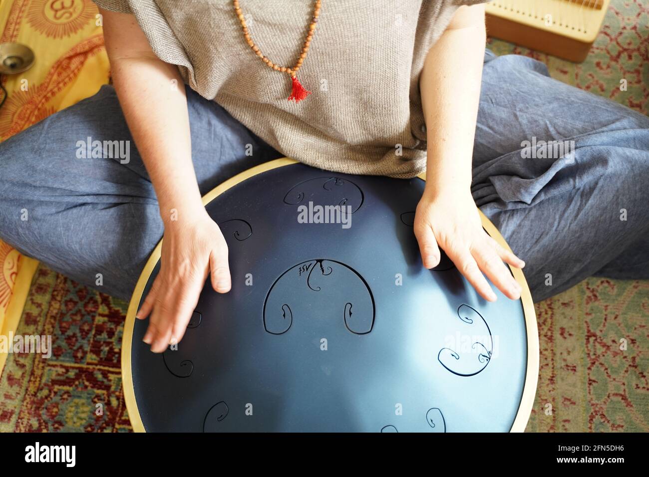 Woman with spielt eine RAV Drum, Nahaufnahme der Hände der Frau, die eine Hang Drum spielen, Musikinstrument zur Klangheilung.Woman spielt eine RAV Drum Stockfoto