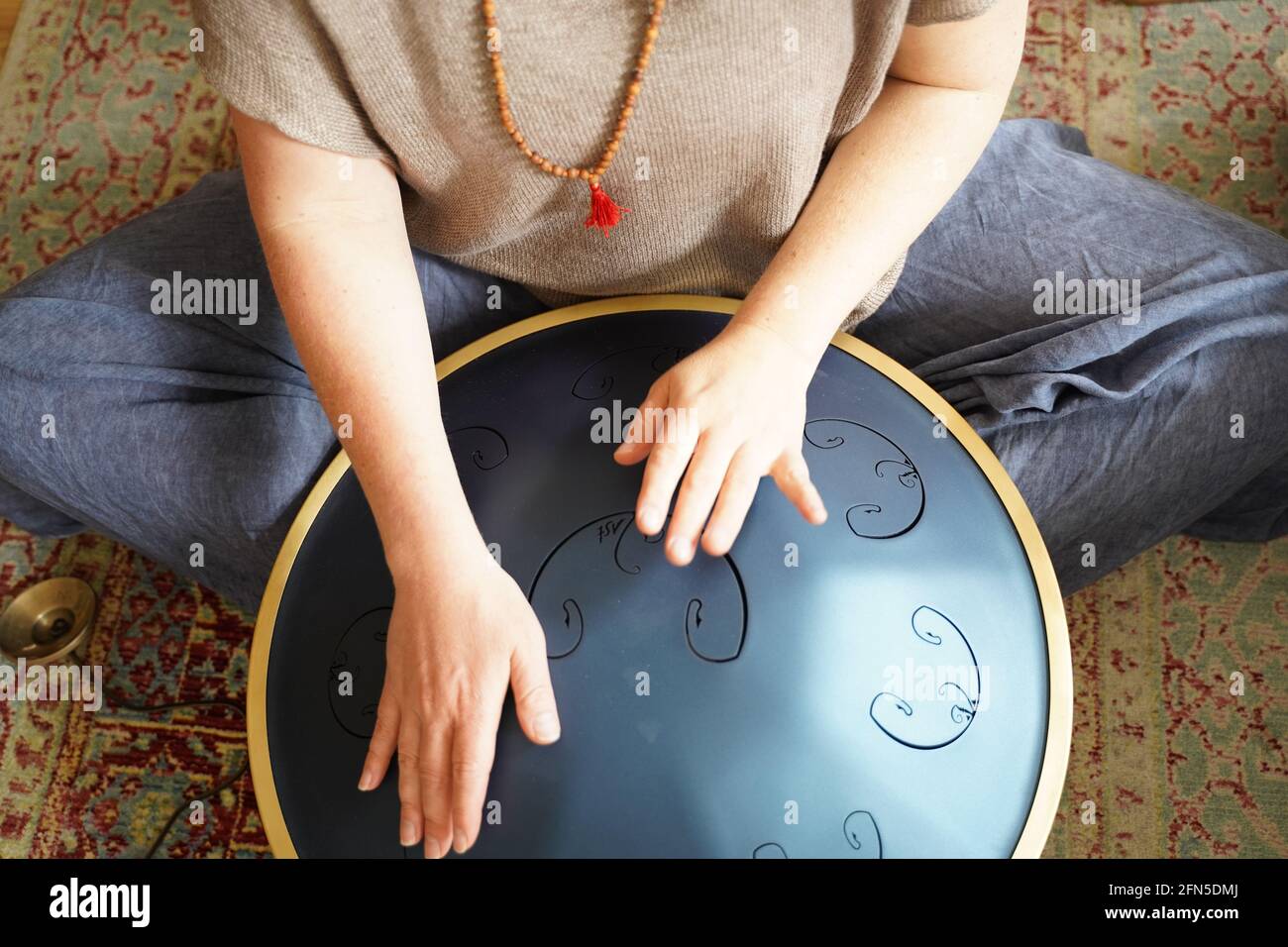 Woman with spielt eine RAV Drum, Nahaufnahme der Hände der Frau, die eine Hang Drum spielen, Musikinstrument zur Klangheilung.Woman spielt eine RAV Drum Stockfoto