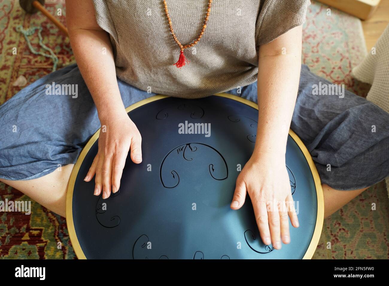 Woman with spielt eine RAV Drum, Nahaufnahme der Hände der Frau, die eine Hang Drum spielen, Musikinstrument zur Klangheilung.Woman spielt eine RAV Drum Stockfoto