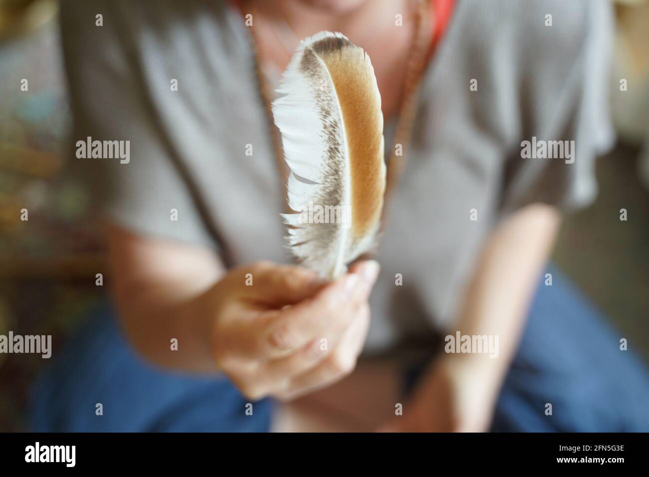 Eine Frau, die eine Feder in der Hand hält. Stockfoto