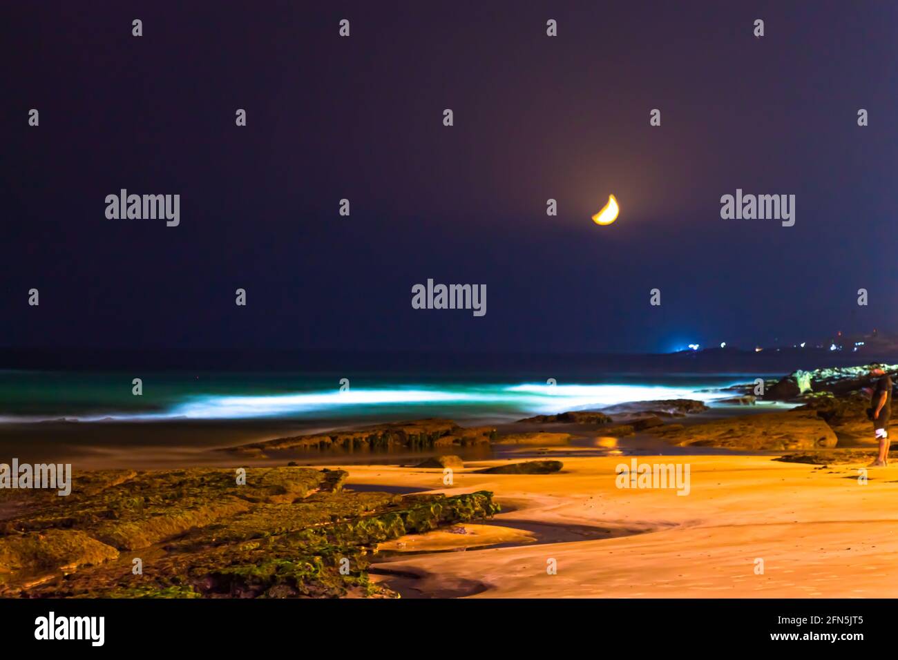 Gelber Halbmond über einem atemberaubenden Strand Stockfoto