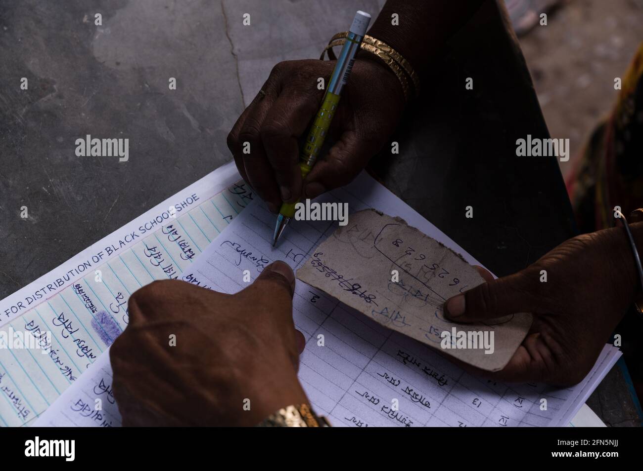 Tehatta, Indien. Mai 2021. Sie kann nicht ordnungsgemäß unterschreiben, so dass sie im Register unterschreibt, nachdem sie sein vorheriges Zeichen gesehen hat. (Foto von Soumyabrata Roy/Pacific Press) Quelle: Pacific Press Media Production Corp./Alamy Live News Stockfoto