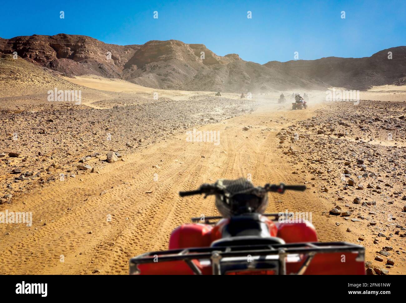 Safari-Tour mit Gruppe von Menschen auf Quad-Bikes, aktive Freizeit in Ägypten Resorts. Extreme Fahrten auf Quads in Steinwüsten. Stockfoto