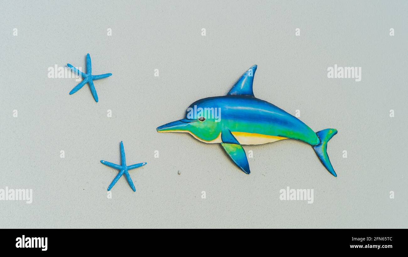 Isolierte Delphin- und Seesterne-Kunst an der grauen Wand Stockfoto