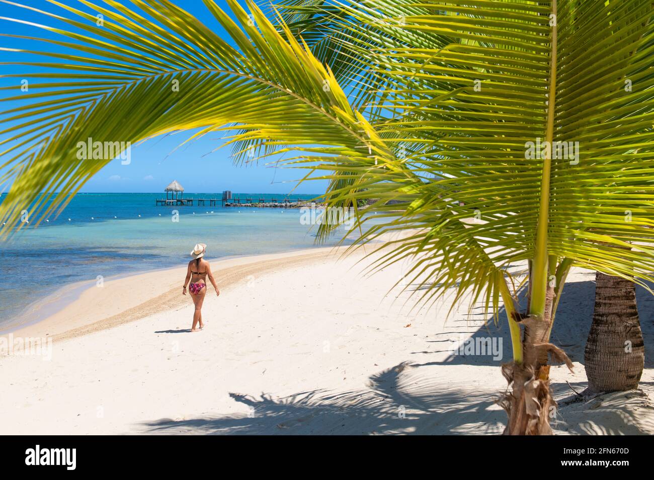 Frau, die an einem karibischen Strand spazierend ist Stockfoto