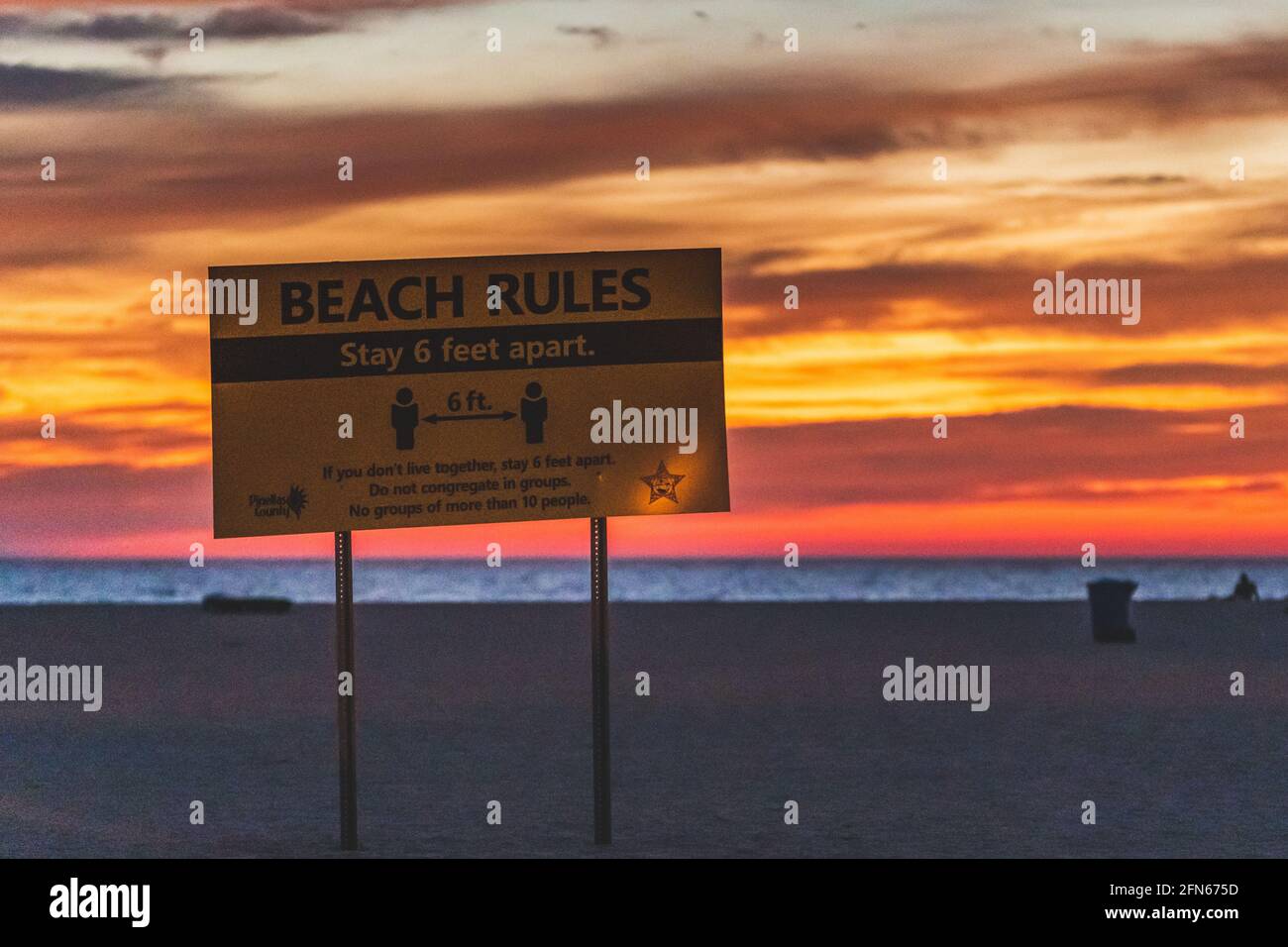 Strandregeln Bleiben Sie 6 Meter auseinander Warnschild Strand gegen Strahlender Himmel bei Sonnenuntergang Stockfoto