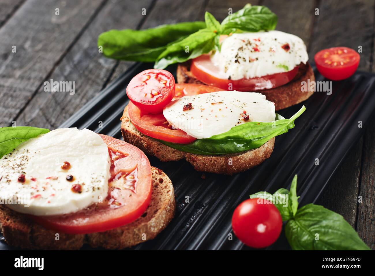 Offene Sandwiches oder Bruschetta mit Mozzarella-Käse, Tomaten und Basilikum, Caprese. Stockfoto