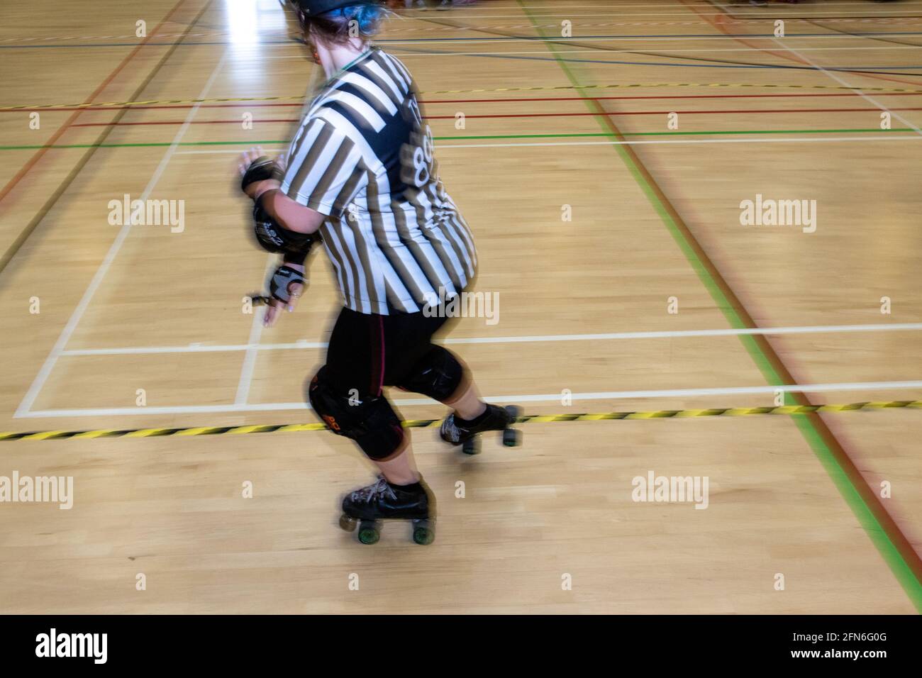 Frau außerhalb der Gleisschiedsrichter beim Skaten auf einem Rollerderby. Stockfoto