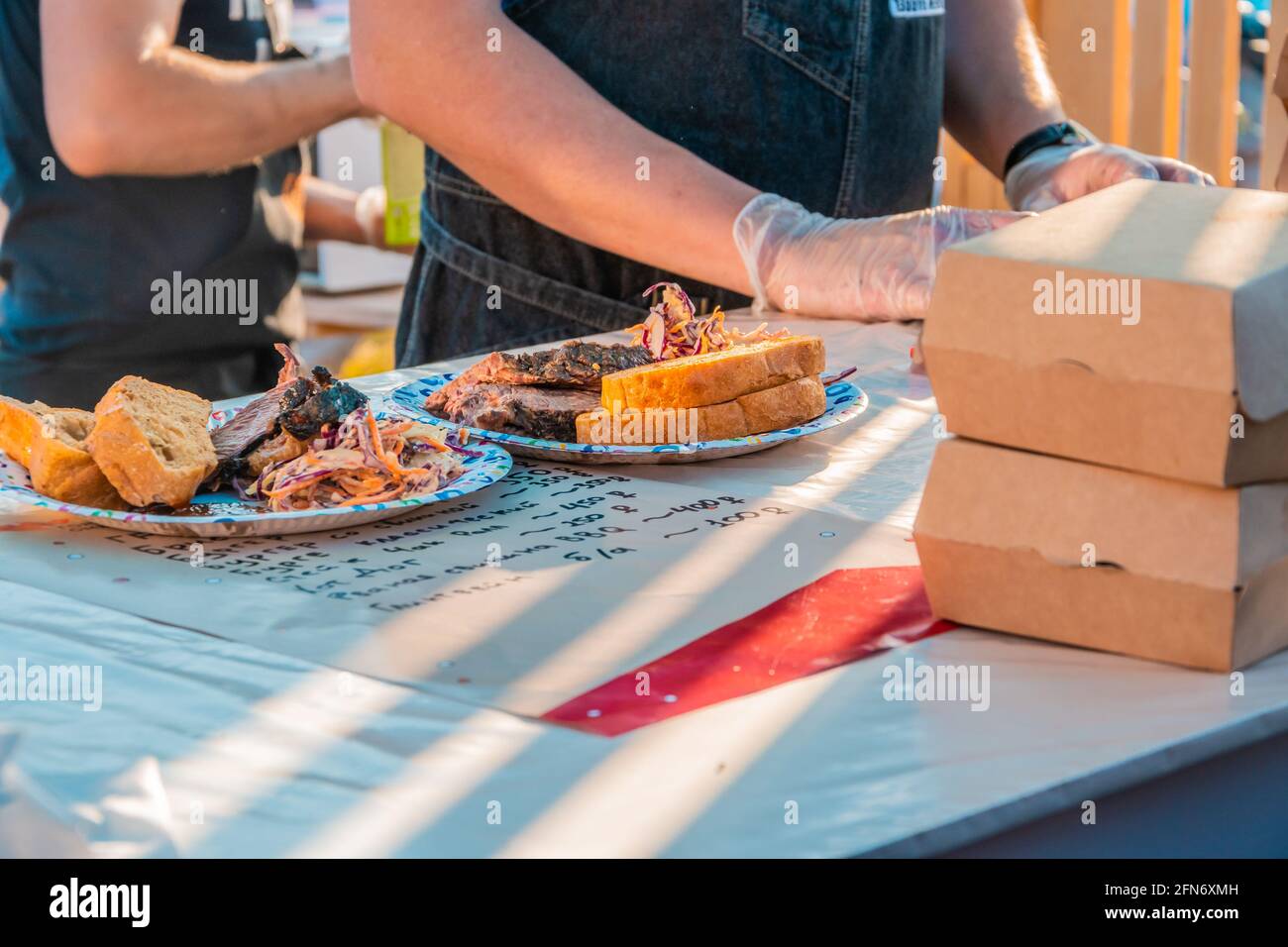 Kazan, Russland - 03. Oktober 2020: Pappteller mit Portionen gebratenem Fleisch, Salat und Brot vor dem Hintergrund eines handgeschriebenen Menüs auf dem Counte Stockfoto