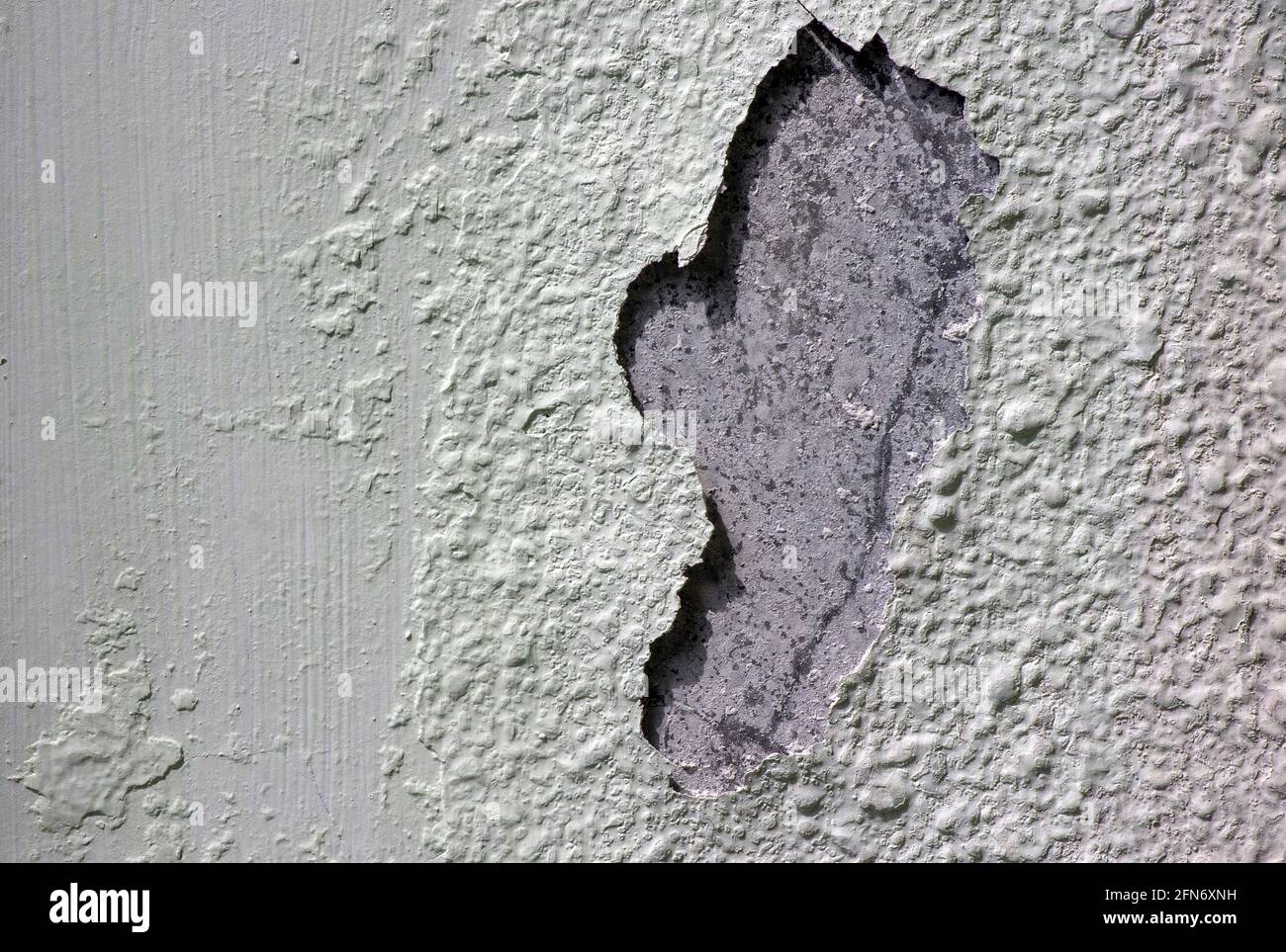 Hellgrüne Betonwandstruktur mit beschädigter Oberfläche Stockfoto