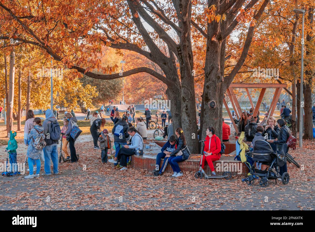 Kazan, Russland - 03. Oktober 2020: Kinder auf Fahrrädern und Motorroller und ihre Eltern im Skatepark im Stadtpark, sonniger Herbsttag. Stockfoto