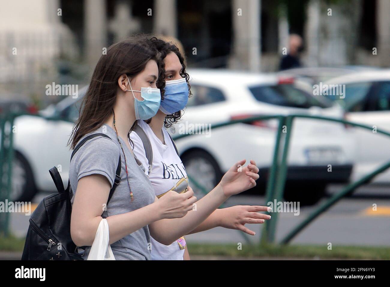 Bukarest, Rumänien. Mai 2021. Menschen mit Gesichtsmasken gehen am 14. Mai 2021 auf einer Straße in Bukarest, Rumänien. Der rumänische Premierminister Florin Citu sagte, die Regierung habe am Freitag eine Entscheidung getroffen, die Einschränkungen im Zusammenhang mit dem Coronavirus ab Samstag schrittweise zu lockern. Quelle: Cristian Cristel/Xinhua/Alamy Live News Stockfoto