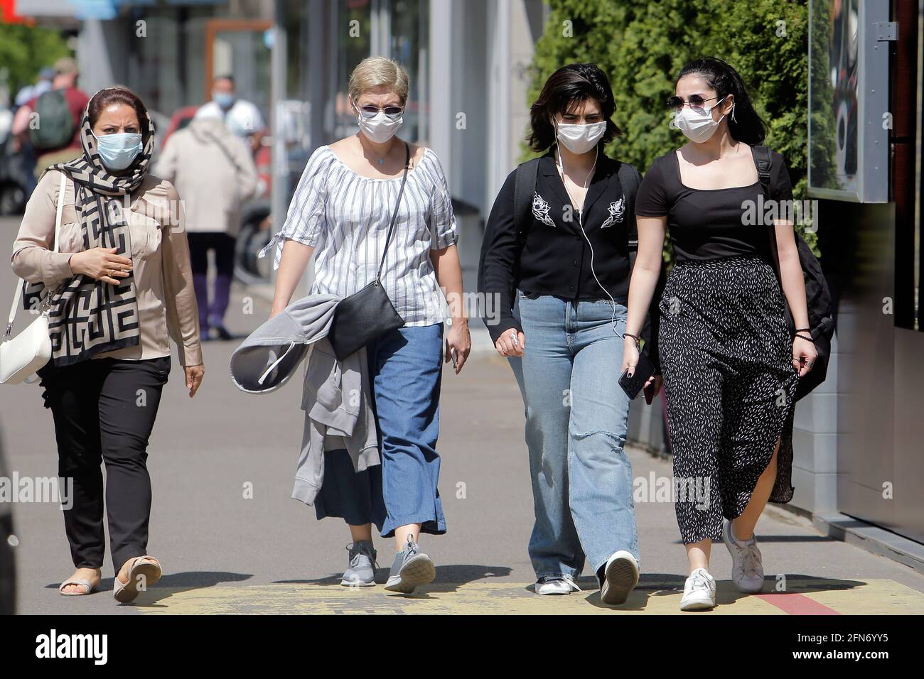 Bukarest, Rumänien. Mai 2021. Menschen mit Gesichtsmasken gehen am 14. Mai 2021 auf einer Straße in Bukarest, Rumänien. Der rumänische Premierminister Florin Citu sagte, die Regierung habe am Freitag eine Entscheidung getroffen, die Einschränkungen im Zusammenhang mit dem Coronavirus ab Samstag schrittweise zu lockern. Quelle: Cristian Cristel/Xinhua/Alamy Live News Stockfoto