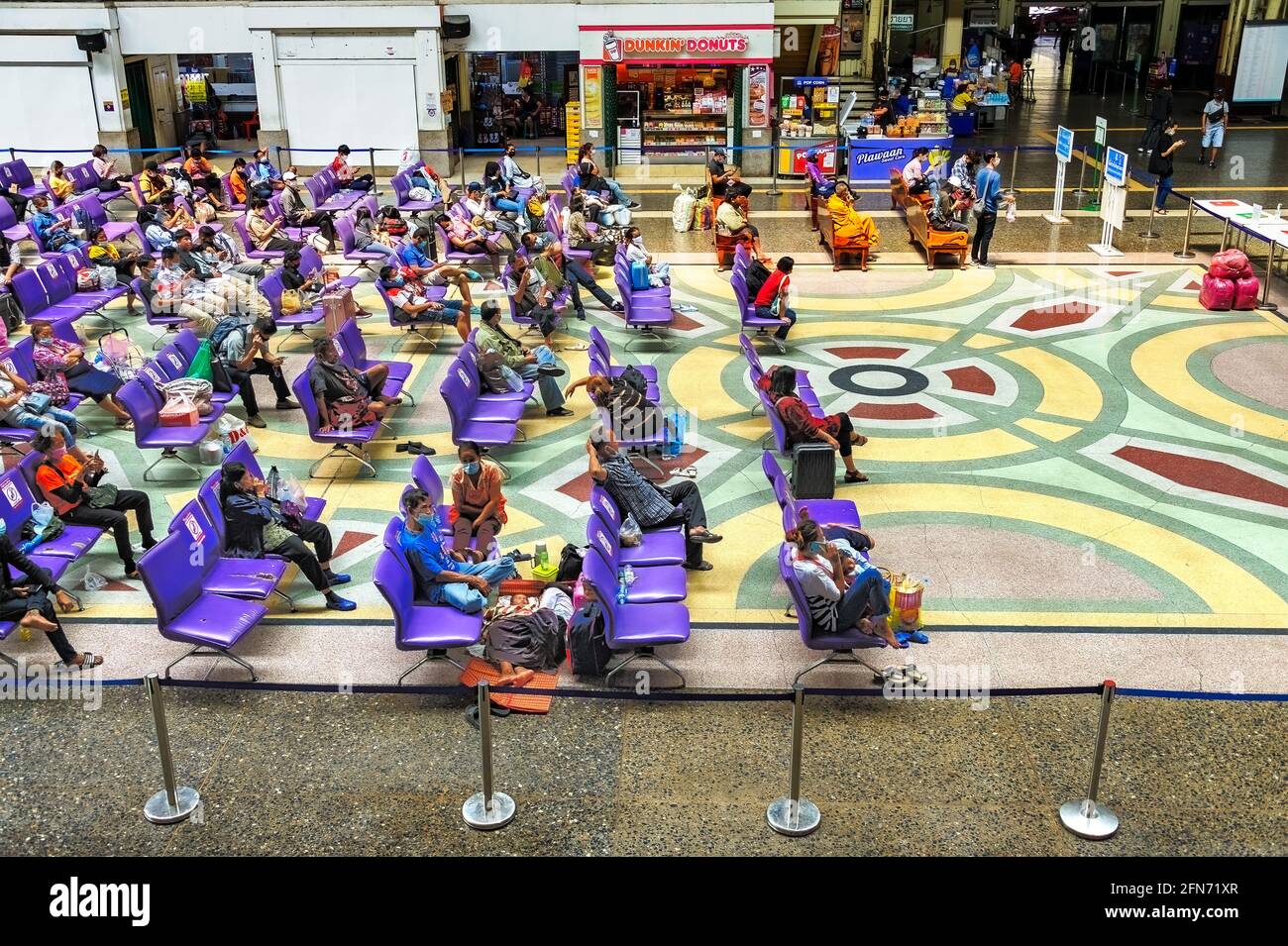 Bangkok, Thailand - 20. März 2021: Pendler in der Wartehalle am Bahnhof Bangkok. Jeder trägt eine Gesichtsmask und hält seine soziale Distanz. Stockfoto