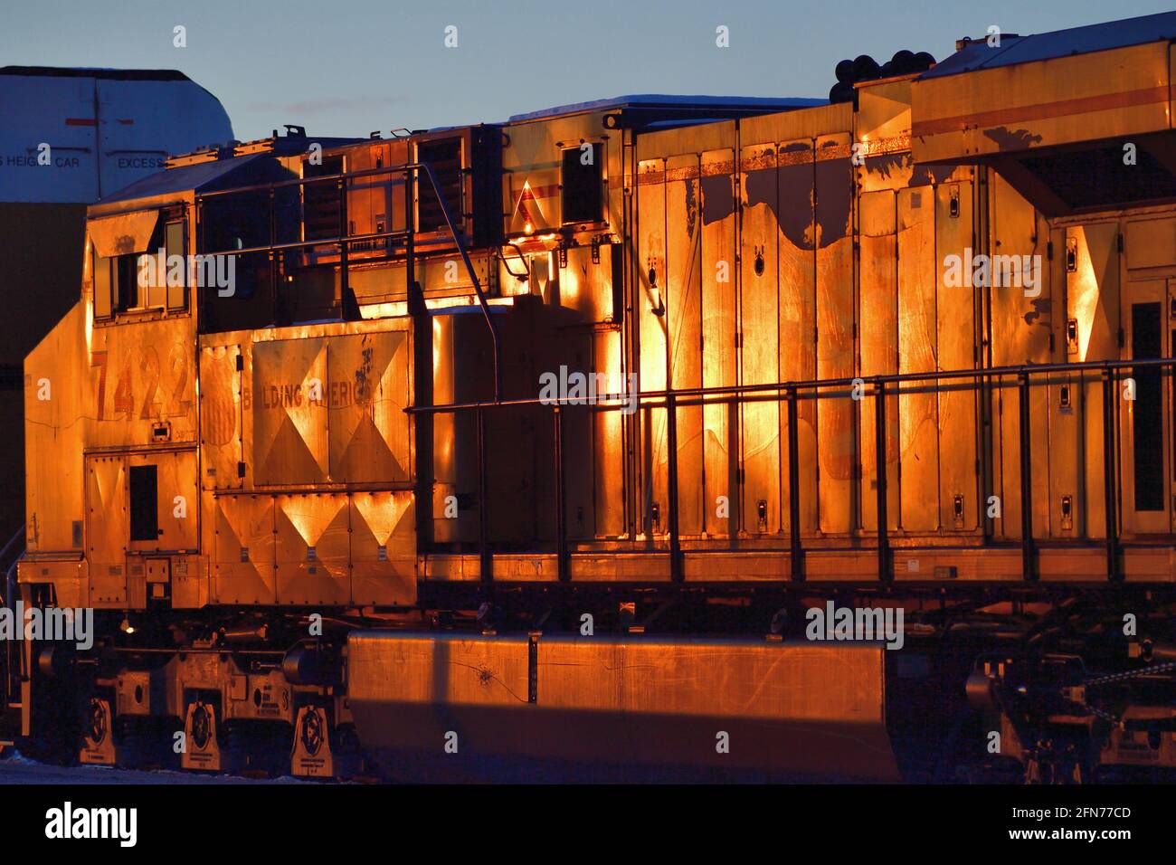 La Fox, Illinois, USA. Die Lokomotiven der Union Pacific Railroad, die einen Güterzug mit Auto-Zahnstange führen, reflektieren die untergehende Wintersonne. Stockfoto