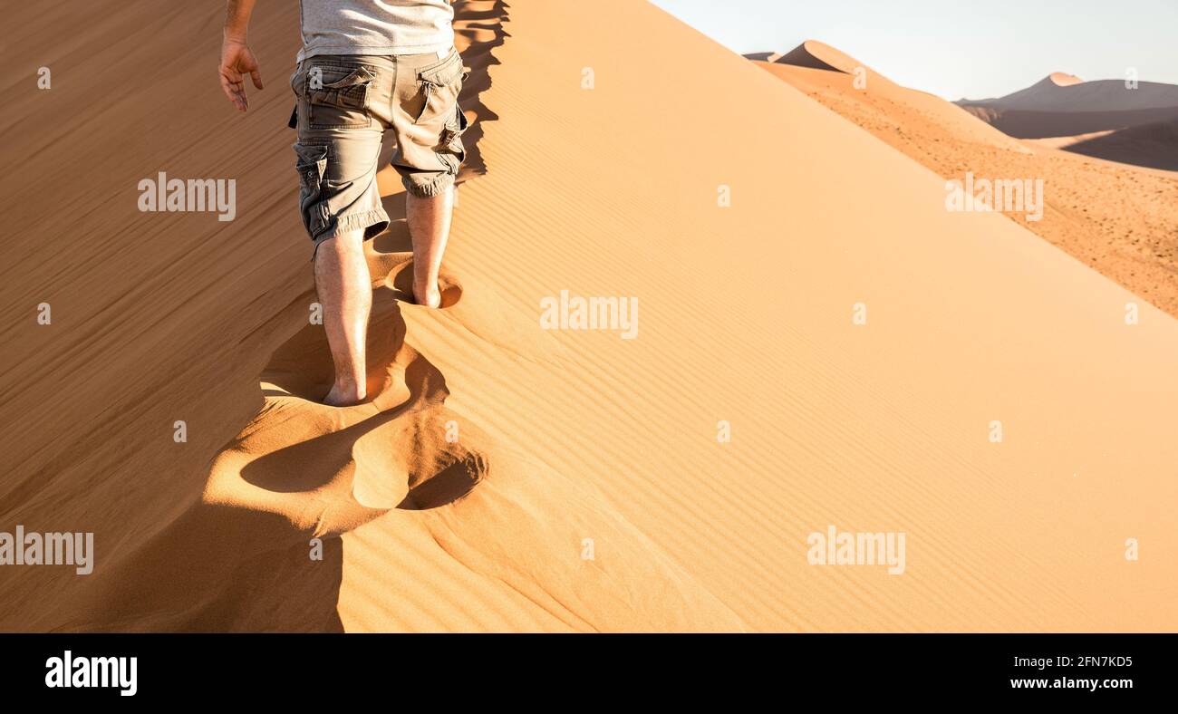 Einsamer Mann zu Fuß auf Sand Crest an der Düne 45 im Sossusvlei Wüste - Wanderlust Konzept mit Wanderer Kerl in der Namibischen berühmten Place - Abenteuer Reise Reisen Stockfoto
