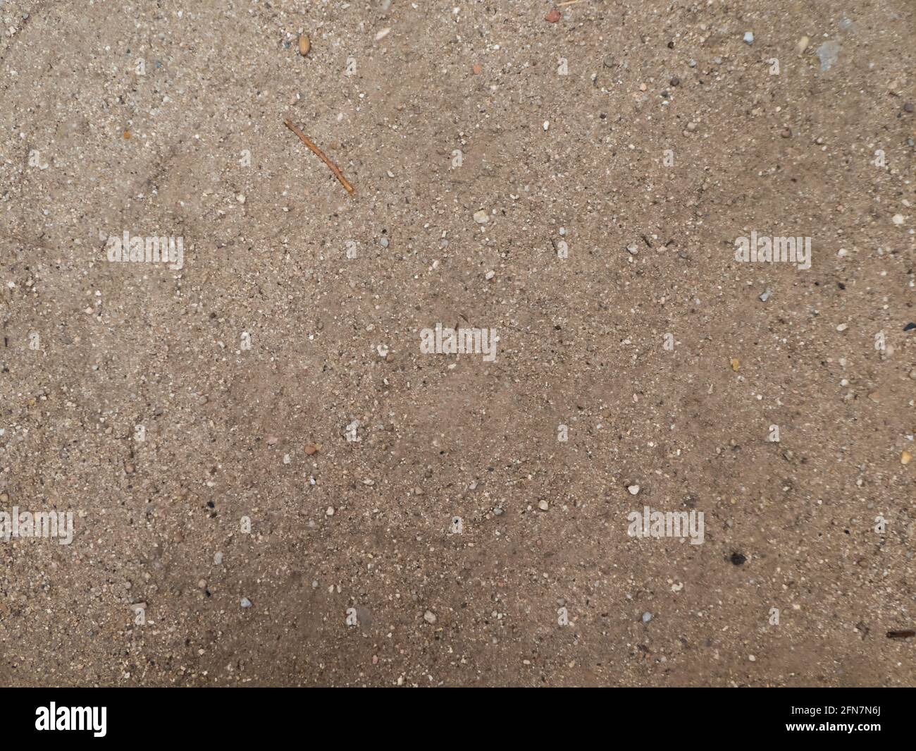 Sandboden mit mehreren Stöcken und Steinen in der Stadt Stockfoto