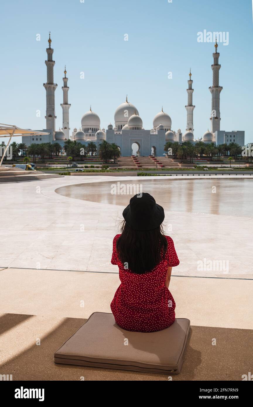 Frau genießt Aussicht Panoramablick auf die große Moschee Sheikh Zayed spiegelt sich im Wasser in Abu Dhabi, Vereinigte Arabische Emirate an einem sonnigen Tag. Große Moschee Stockfoto