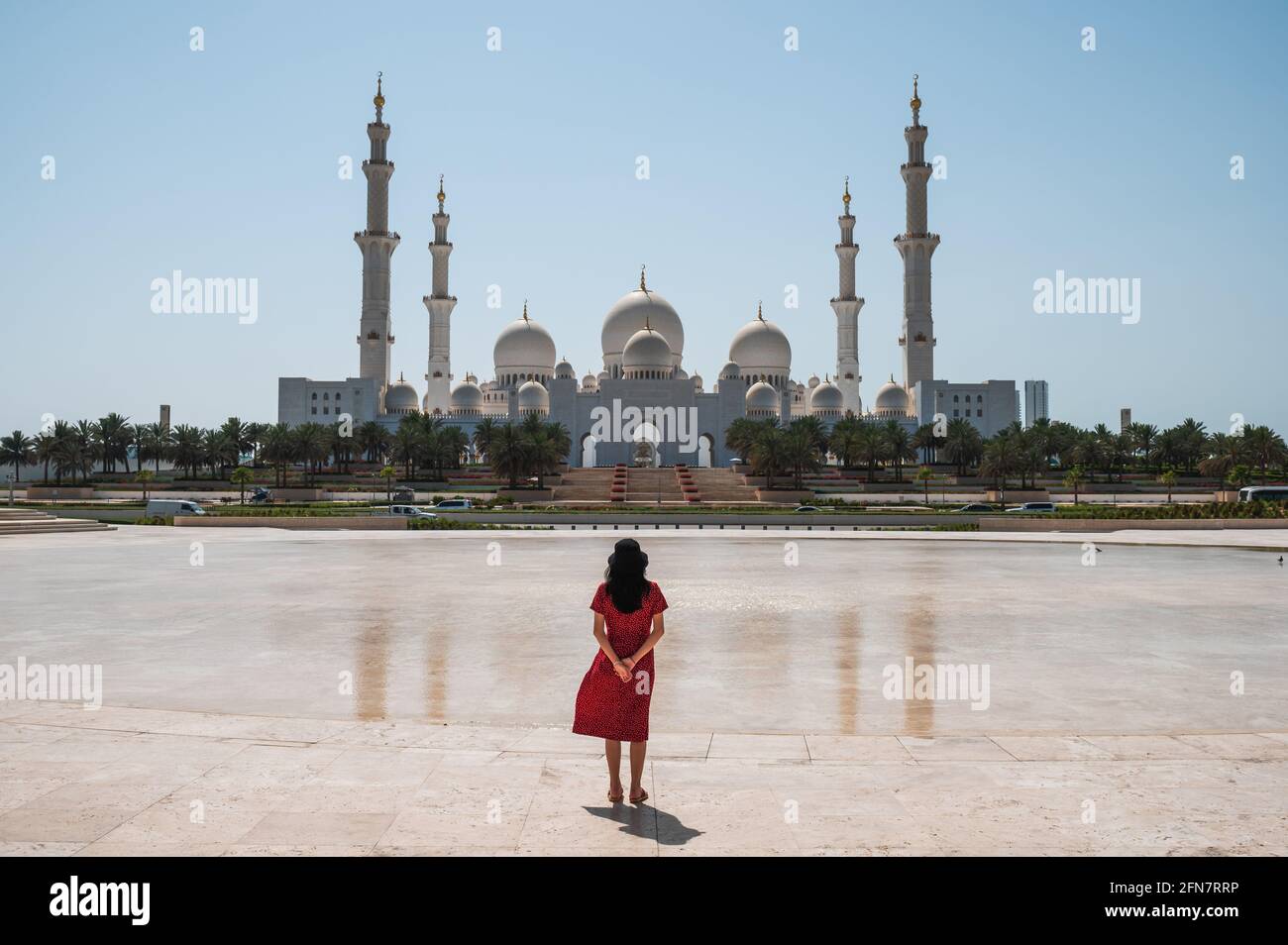 Frau genießt Aussicht Panoramablick auf die große Moschee Sheikh Zayed spiegelt sich im Wasser in Abu Dhabi, Vereinigte Arabische Emirate an einem sonnigen Tag. Große Moschee Stockfoto