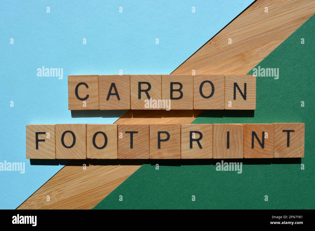 CO2-Fußabdruck, Wörter in Holzbuchstaben isoliert auf buntem Hintergrund Stockfoto