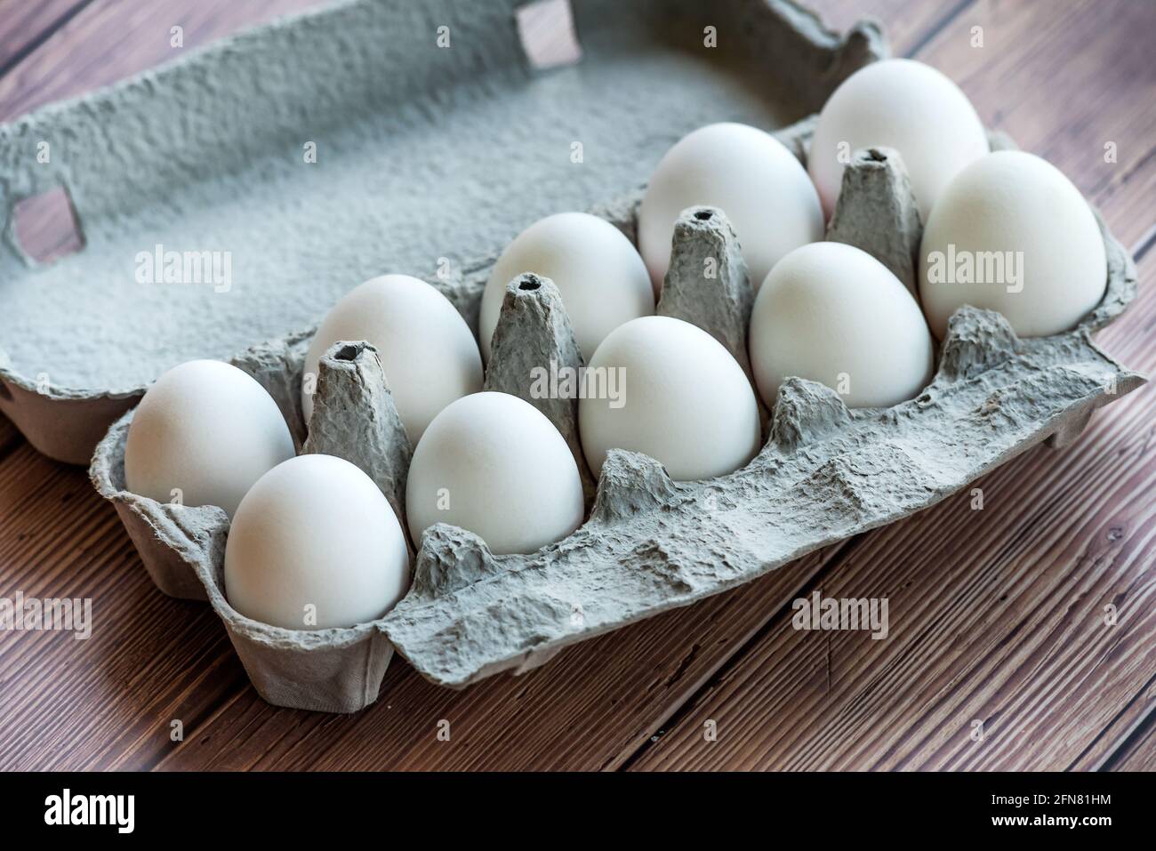 Ein Eierkarton aus Pappe mit zehn weißen Eiern auf einem Holztisch. Eier in  einer Schachtel Stockfotografie - Alamy