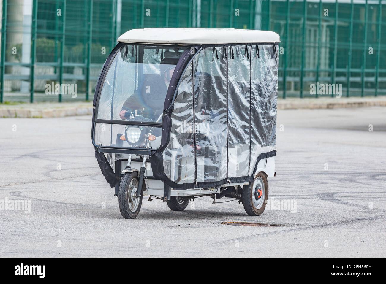 Moto-Rikscha mit Passagieren bewegt sich auf der Stadtstraße. Stockfoto