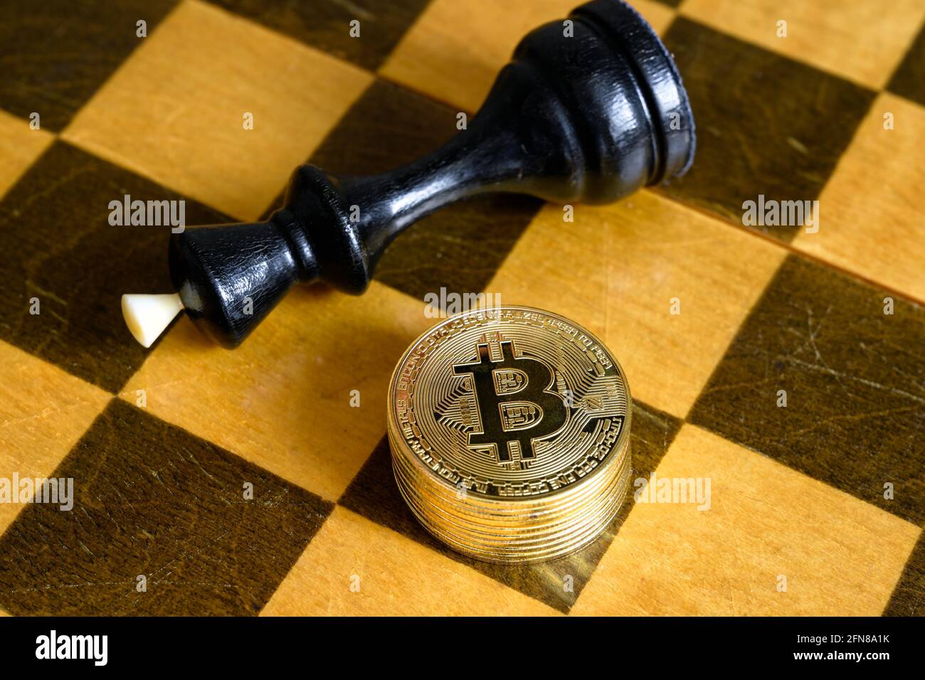 Schachkönig und Bitcoin auf Holzchessboard, Goldmünzen stapeln und spielen vorbei. Konzept der Finanzstrategie, virtuelles Geld, Kryptowährungsinvestition Stockfoto