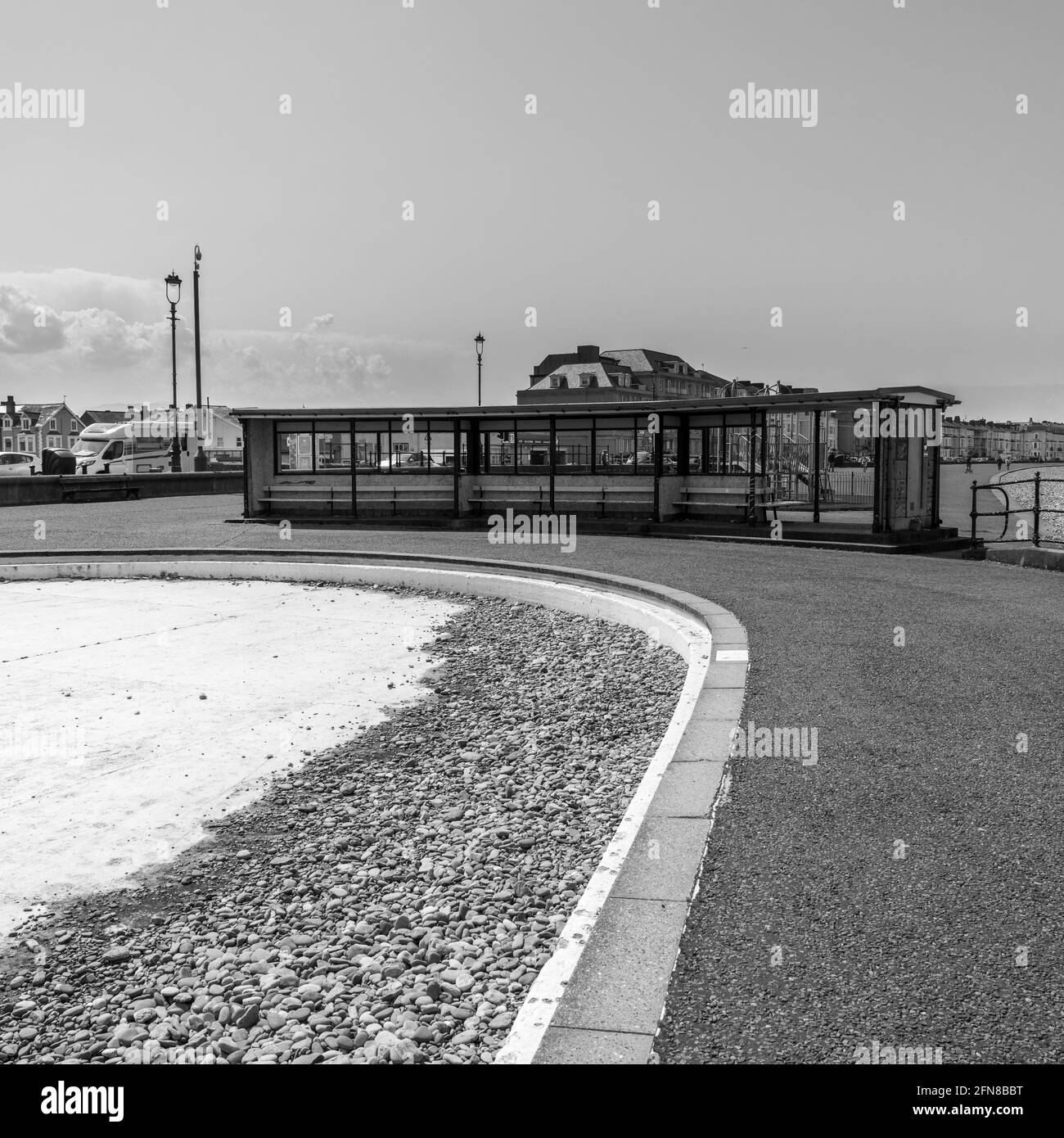 Ein Schwarz-Weiß-Foto, das das öffentliche Planschbecken in Llandudno zeigt, wird geleert und liegt voller Kieselsteine vom Strand entfernt. Stockfoto