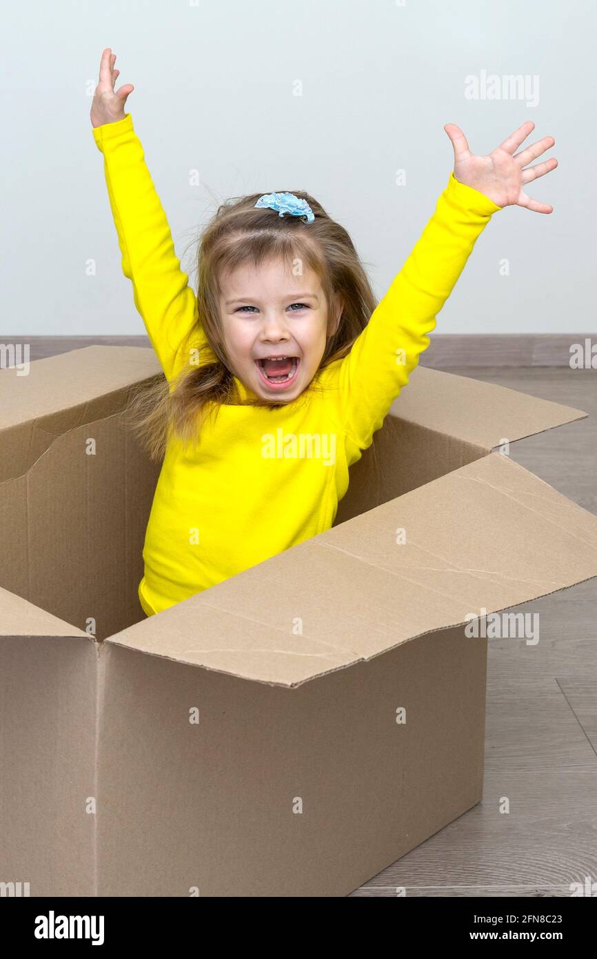Umzug in eine neue Wohnung. Glückliches Baby in einem Karton Stockfoto