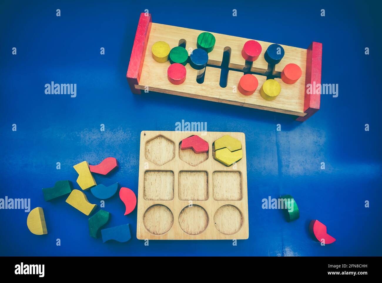Draufsicht auf Spielzeugblöcke auf blauem Hintergrund. Verschiedene Form bunt in rot, gelb, grün und blau aus Holz erstellt. Pädagogisches Spielzeug für Kindergarten Stockfoto