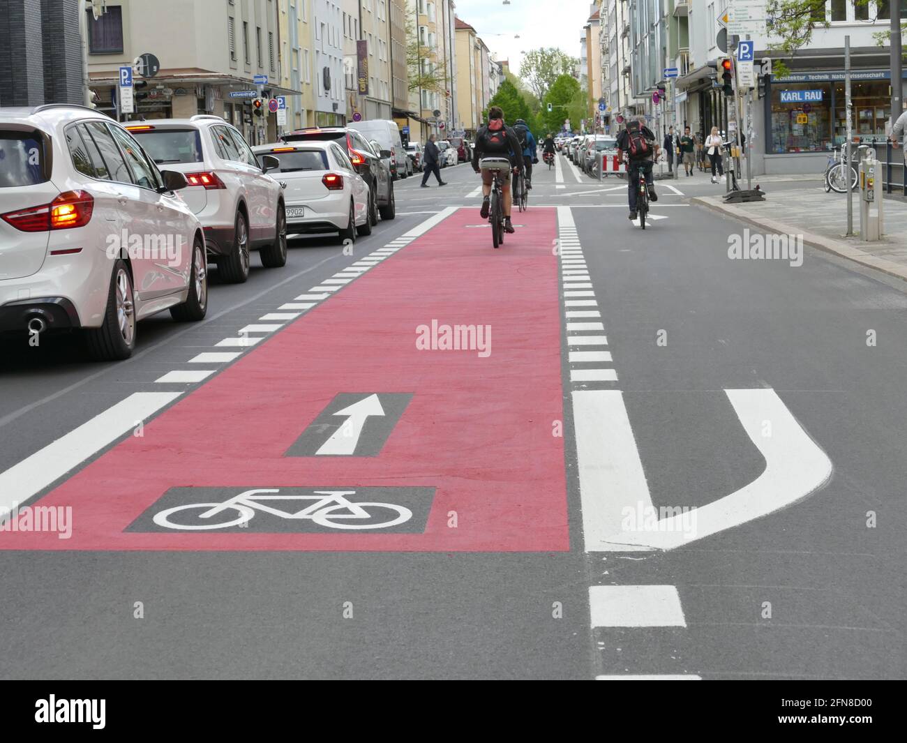 Grüne Politik. Frischer Fahrradweg, rot gefärbt, für sicheres Fahrradfahren im Universitätsviertel münchen. Stockfoto