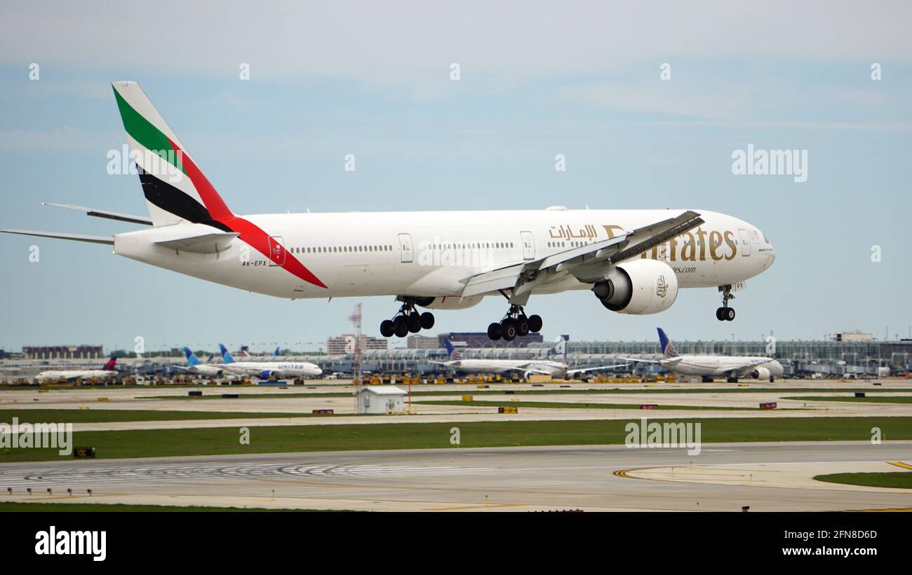 Emirates Boeing 777-300ER landet an einem bewölkten Frühlingstag auf dem Chicago O'Hare International Airport. Der Flug begann in Dubai. Stockfoto