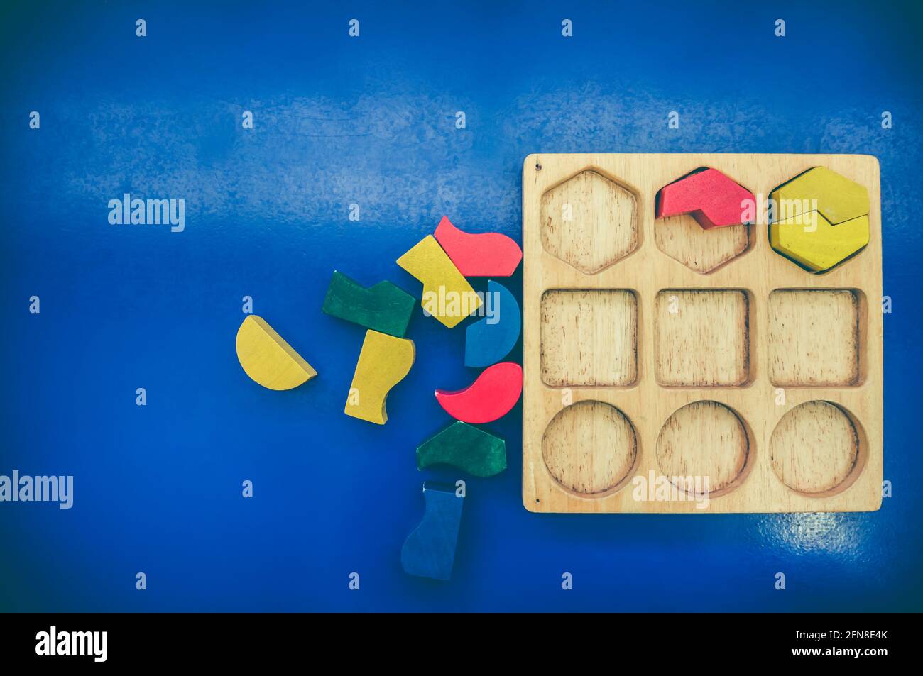 Draufsicht auf Spielzeugblöcke auf blauem Hintergrund. Verschiedene Form bunt in rot, gelb, grün und blau aus Holz erstellt. Pädagogisches Spielzeug für Kindergarten Stockfoto