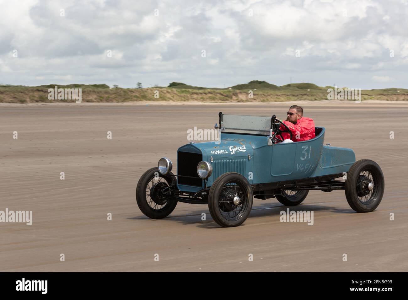 Old Classic Car Hot Rod rast am Pendine Sands Beach in Wales entlang. Stockfoto