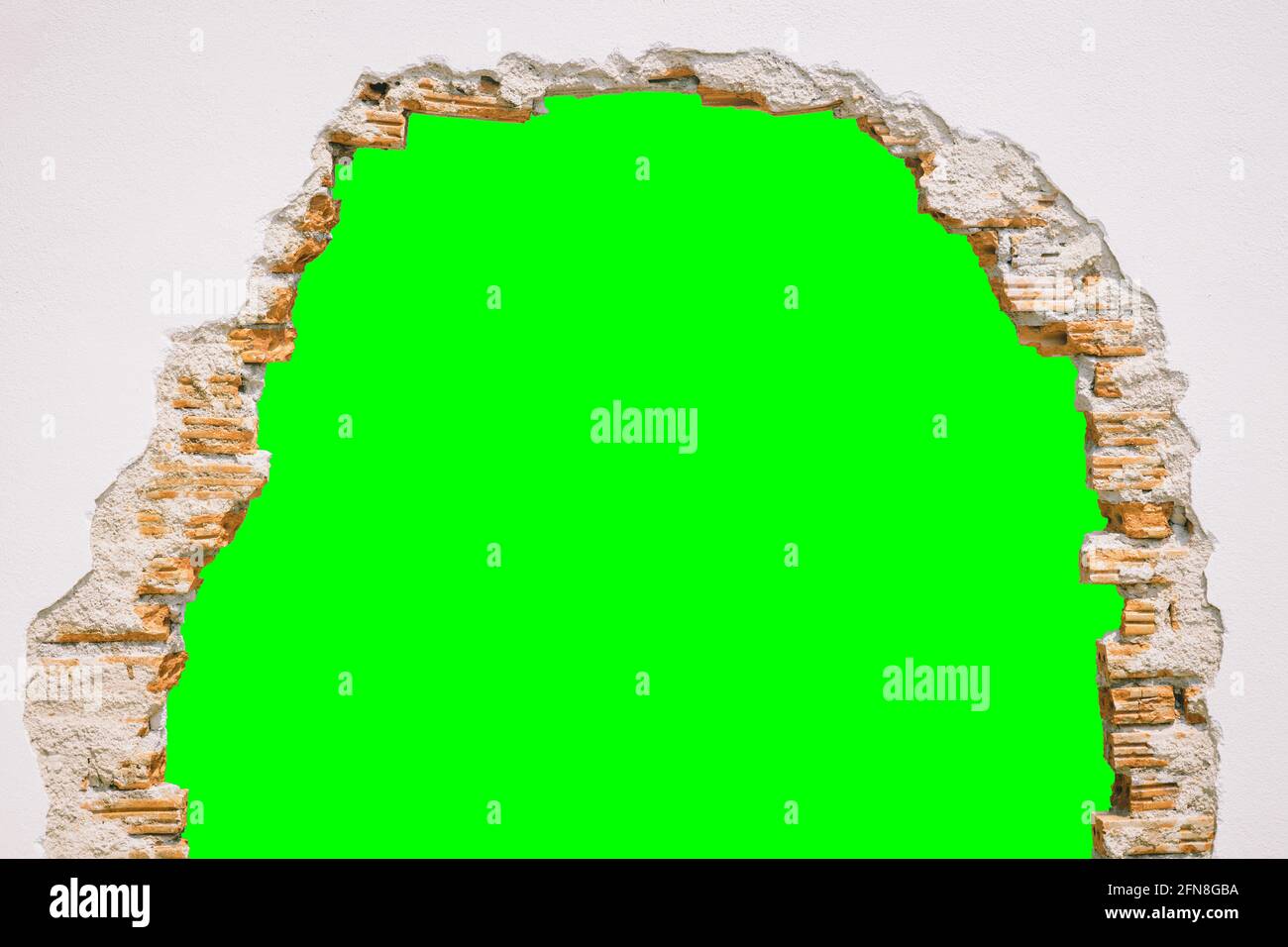 Wanddurchbruch mit grünem Bildschirmhintergrund. Stockfoto