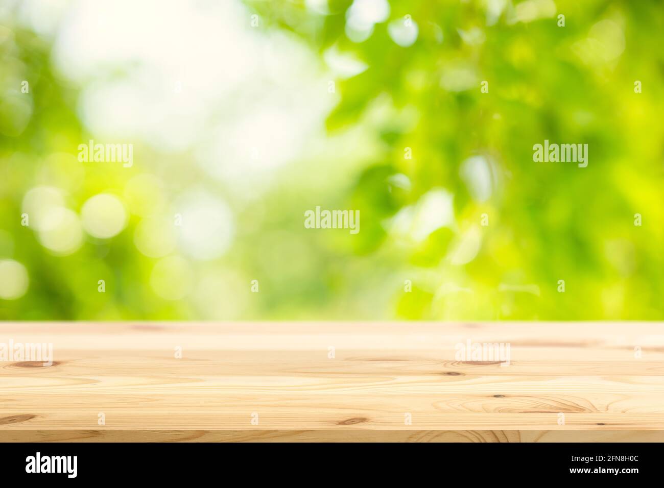 Blur grünen Garten Natur Hintergrund mit Holztisch Platz für Produkte Werbung Montage Overlay Vorlage. Stockfoto