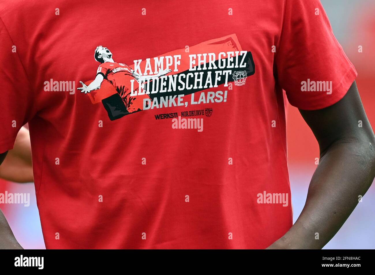 15. Mai 2021, Nordrhein-Westfalen, Leverkusen: Fußball: Bundesliga, Bayer Leverkusen - 1. FC Union Berlin, 33. Spieltag in der BayArena. Das T-Shirt eines Spielers hat „Kampf Ehrgeiz Leidenschaft Danke Lars!“ Aufgedruckt. Der ehemalige internationale Lars Bender wird nach Ende seiner Karriere zum Ehrenkapitän von Bayer Leverkusen ernannt. WICHTIGER HINWEIS: Gemäß den Bestimmungen der DFL Deutsche Fußball Liga und/oder des DFB Deutscher Fußball-Bund ist es untersagt, im Stadion und/oder vom Spiel aufgenommene Fotos in Form von Sequenzbildern und/oder videoähnlichen Fotoserie zu verwenden oder zu verwenden Stockfoto