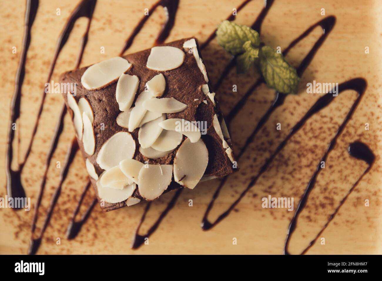 Frische Brownie süß gesunde Lebensmittel. Leckere leckere leckere Schokoladenkuchen mit Mandelflocken Dekoration auf Holzplatte. Stockfoto