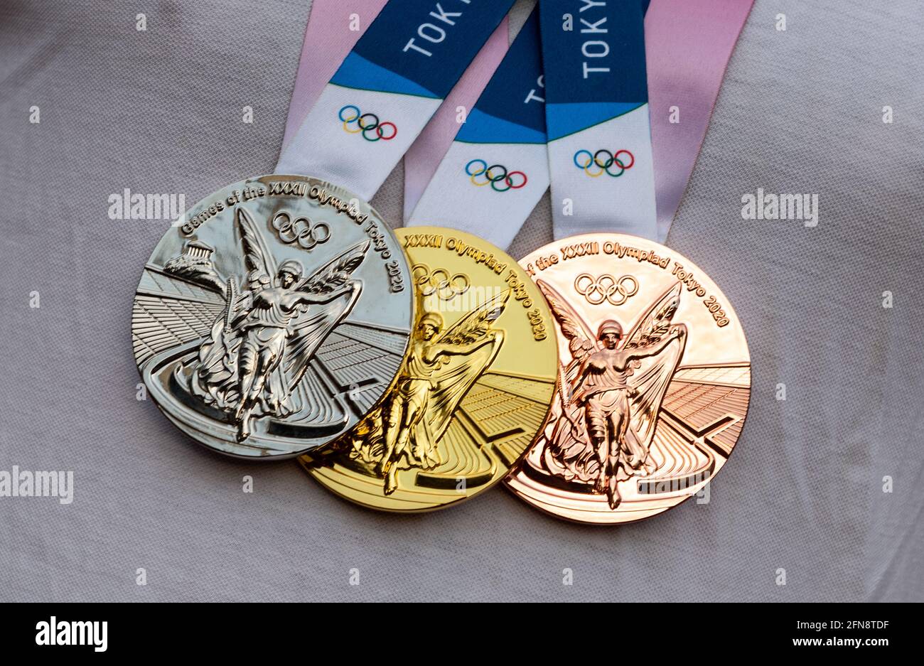 17. April 2021 Tokio, Japan. Gold-, Silber- und Bronzemedaillen der XXXII. Olympischen Sommerspiele in Tokio auf der Brust des Athleten. Stockfoto