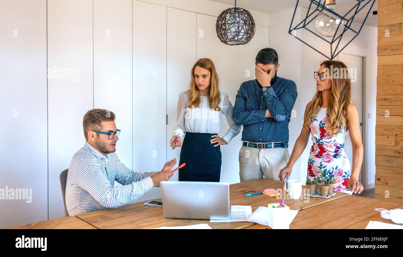 Das Management-Team beschimpft einen inkompetenten Mitarbeiter im Büro Stockfoto