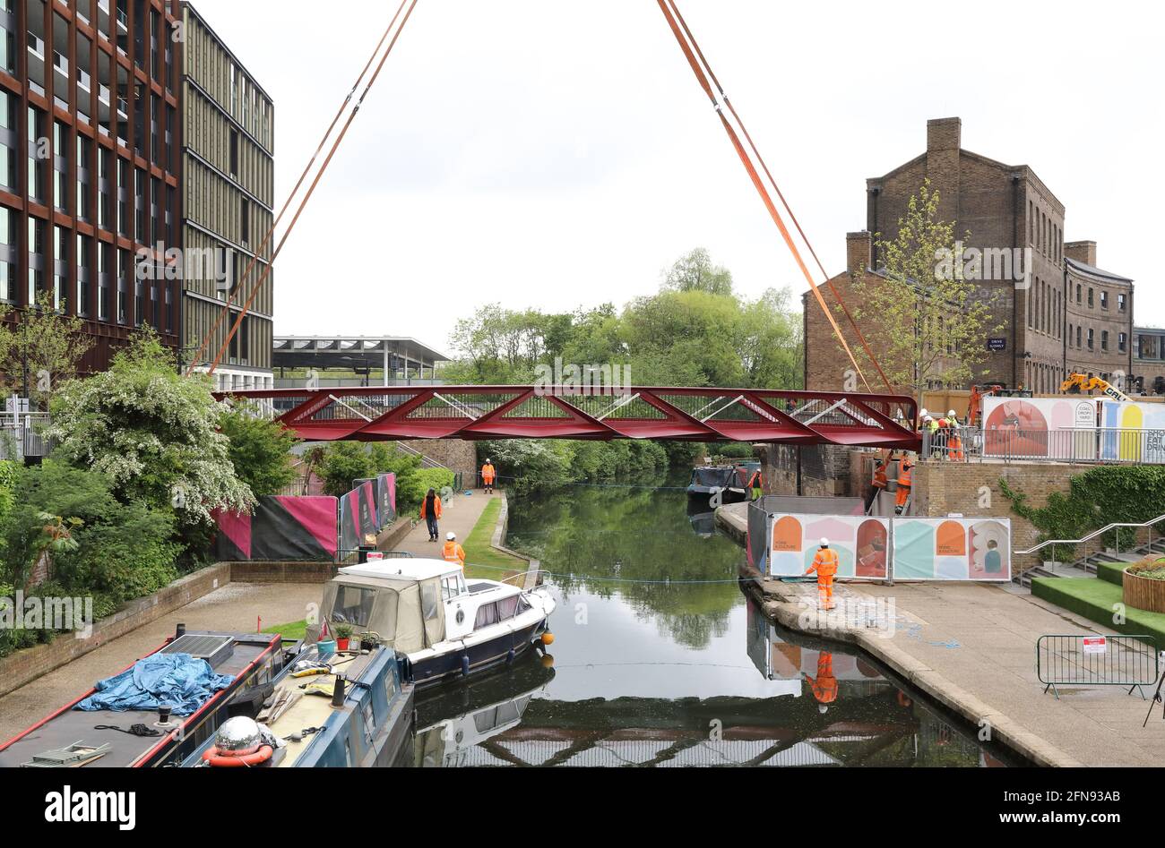London, Großbritannien, 15. Mai 2021, Neue Fußgängerbrücke wird über den Regents Canal am Granary Square am Kings Cross installiert. Menschenmengen versammelten sich, um zuzusehen und jubelten über die Fertigstellung. Monica Wells/Alamy Live News Stockfoto