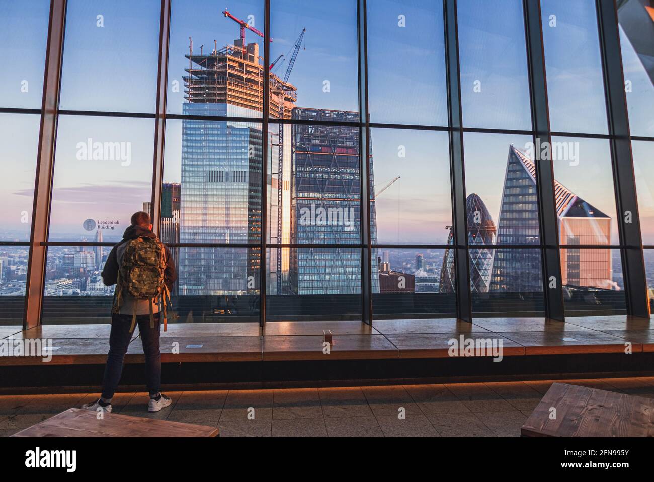 Sonnenaufgang und Wolkenkratzer durch Glasfenster vom Sky Garden in London Stockfoto